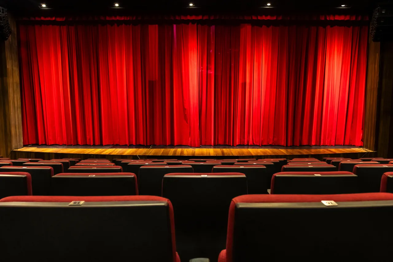 Puste czerwone fotele kinowe czekają na widz&oacute;w. Za chwilę kurtyna się podniesie i dowiemy się, o co biega spektakl.