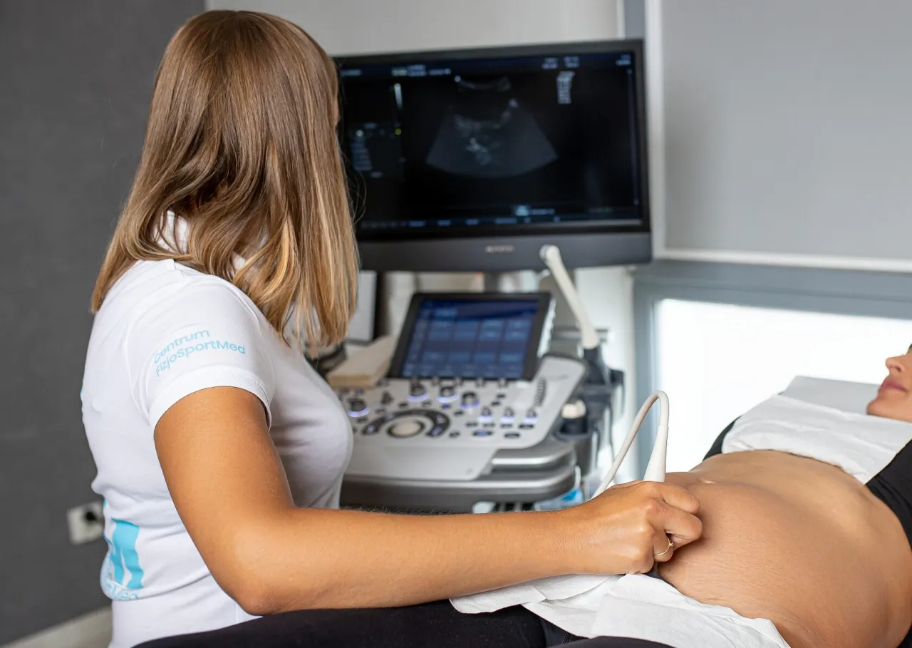 Fizjoterapeuta uroginekologiczny wyjaśnia pacjentce model miednicy