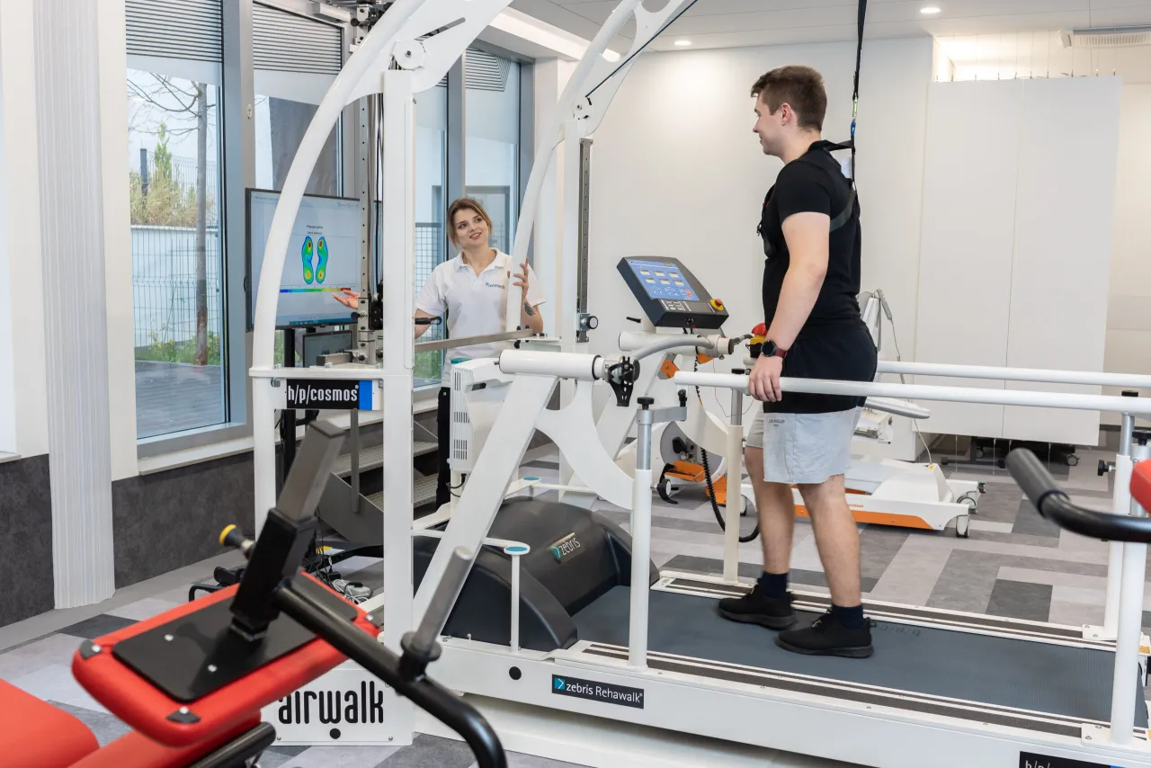 Fizjoterapeuta pokazuje pacjentowi ćwiczenia, gabinet fizjoterapii