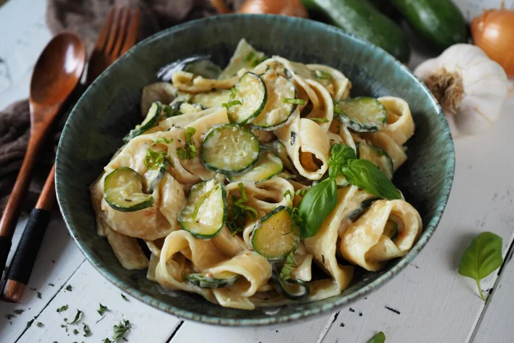 Verschiedene Teller mit Zucchini Pasta Variationen nebeneinander