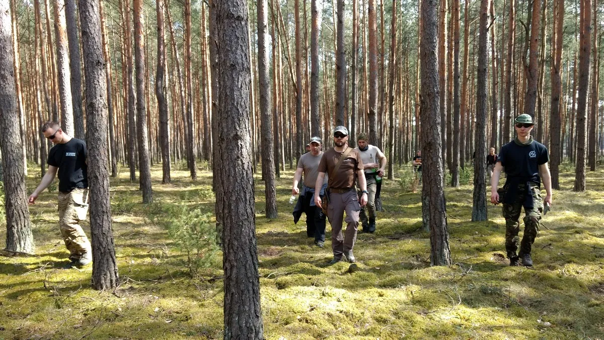 osoba w lesie w długim ubraniu