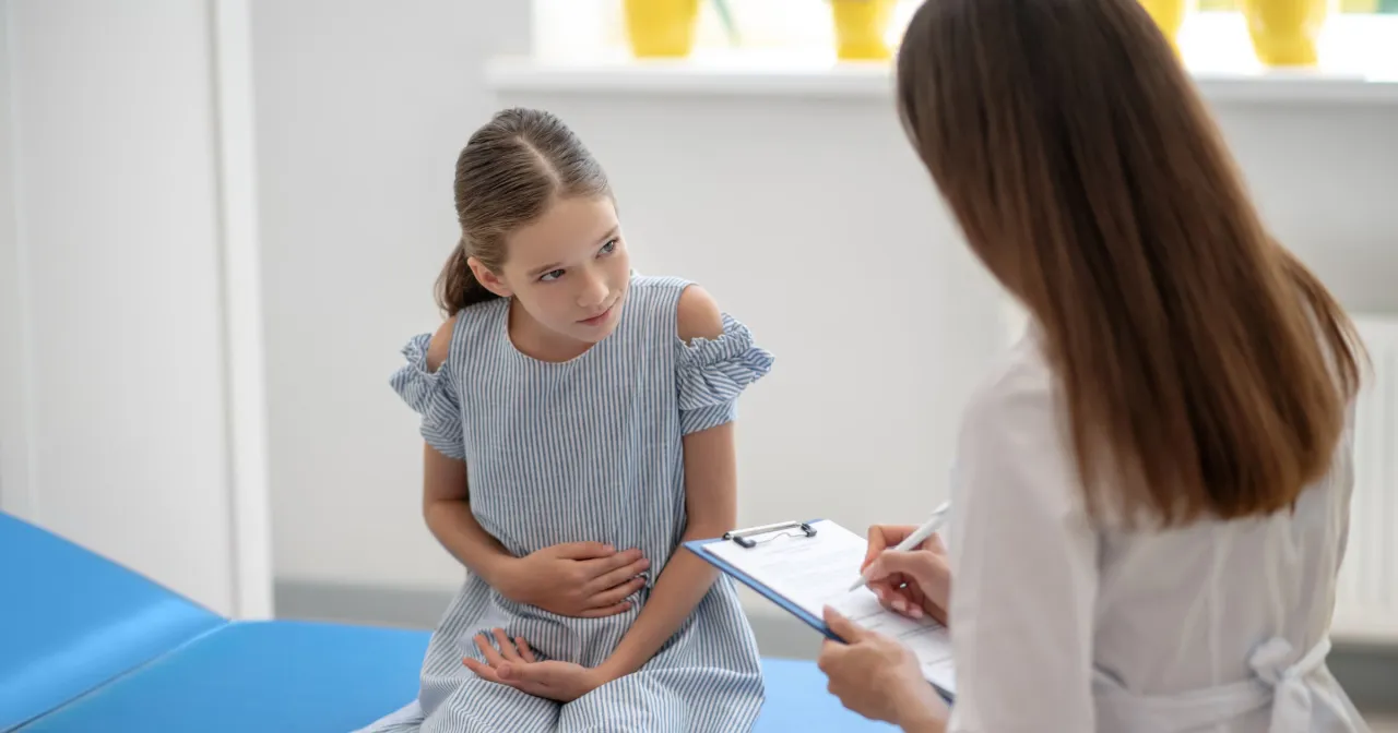 Rodzic z dzieckiem u lekarza pediatry, konsultacja b&oacute;lu brzucha