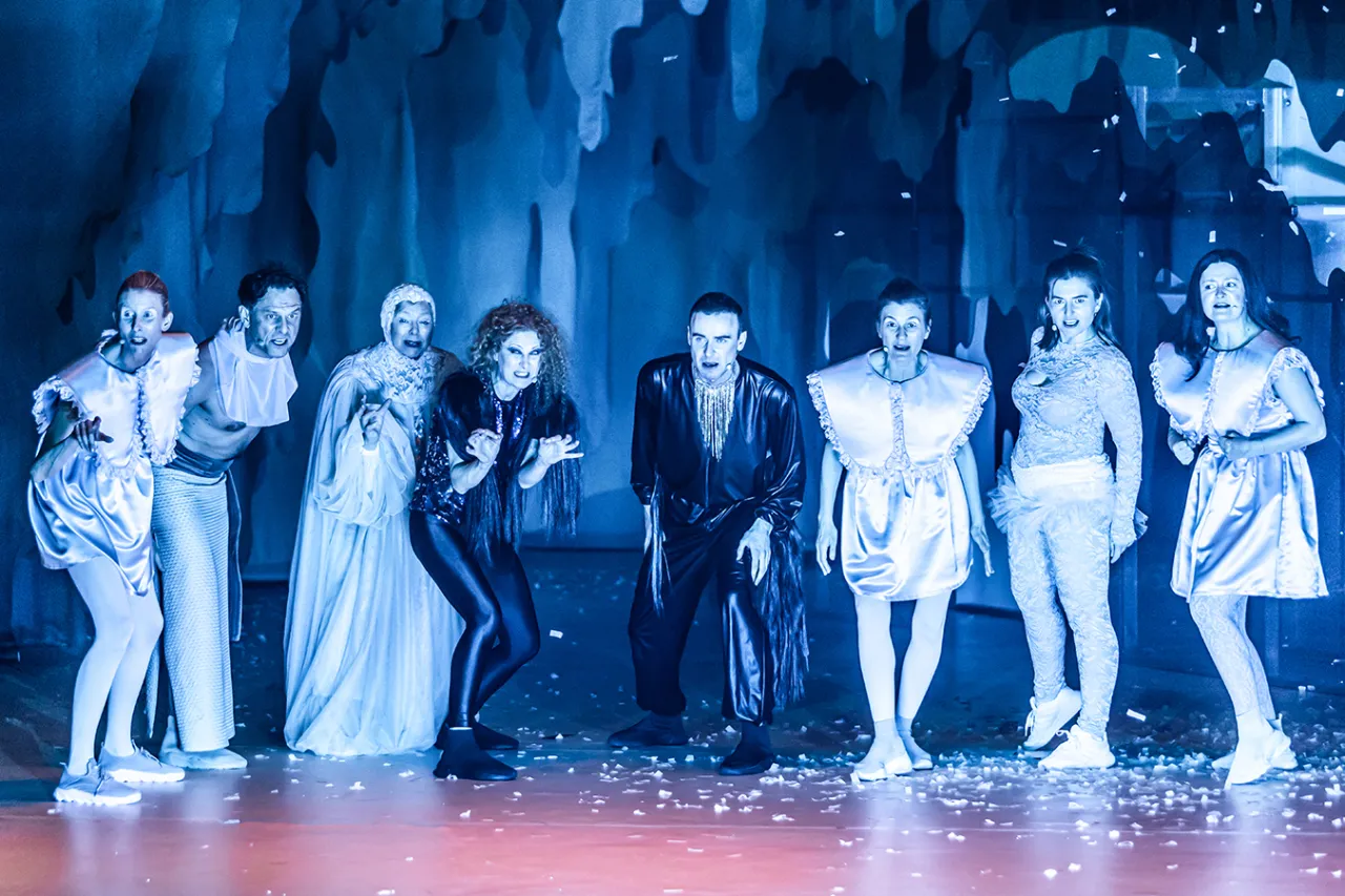 Aktorzy w fantazyjnych strojach na scenie, tworzący jedne z najlepszych spektakli teatralnych.