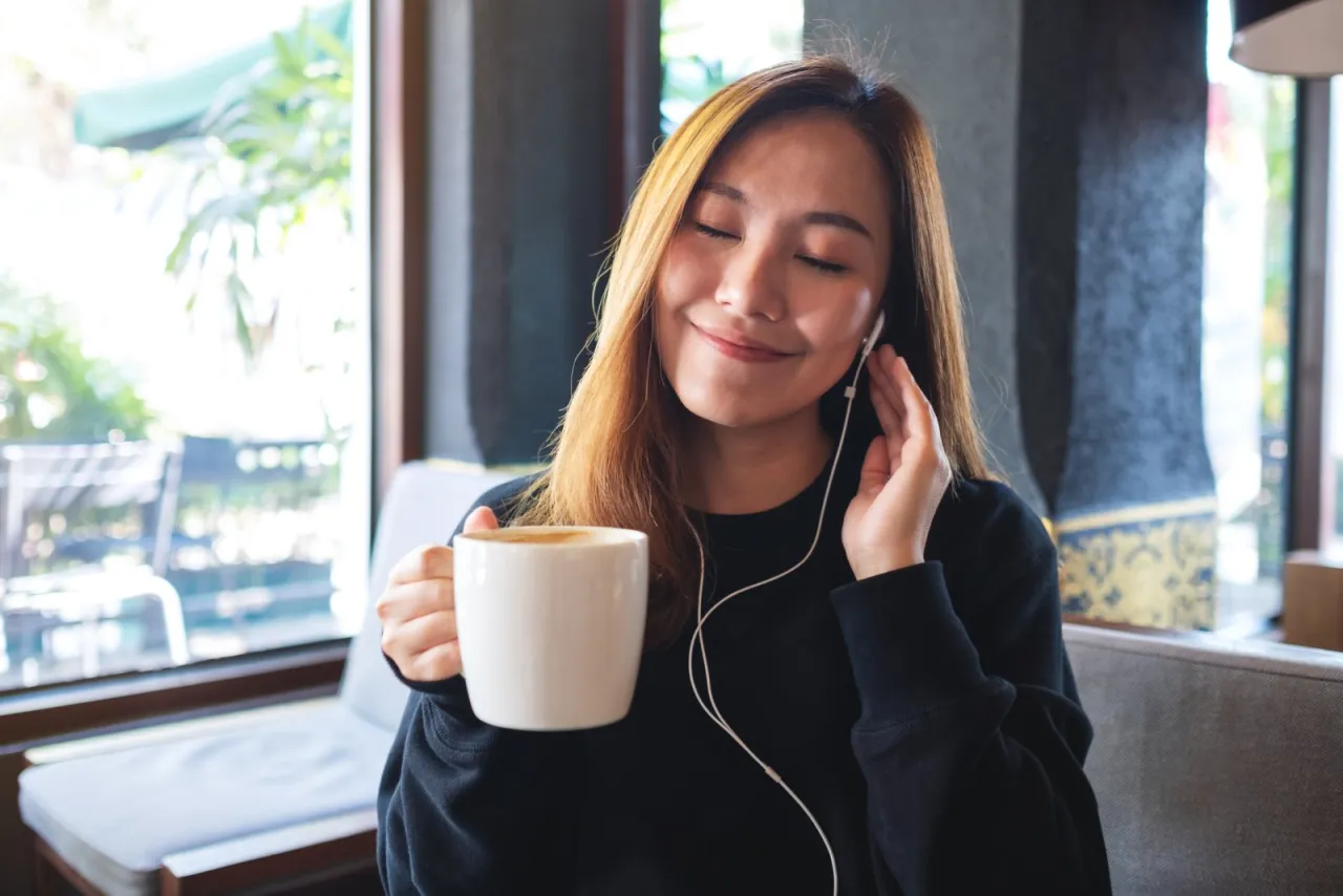 osoba pijąca kawę z uśmiechem