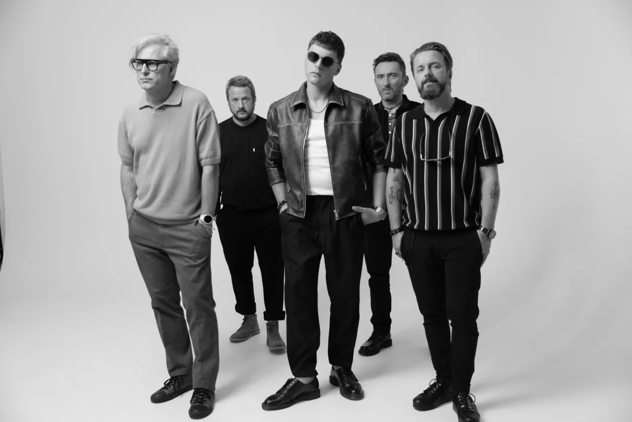 Pięciu mężczyzn w stylowych strojach, jakby właśnie skończyli koncert. Czy to oni są tymi, kt&oacute;rzy śpiewają sprzedawcy marzeń?