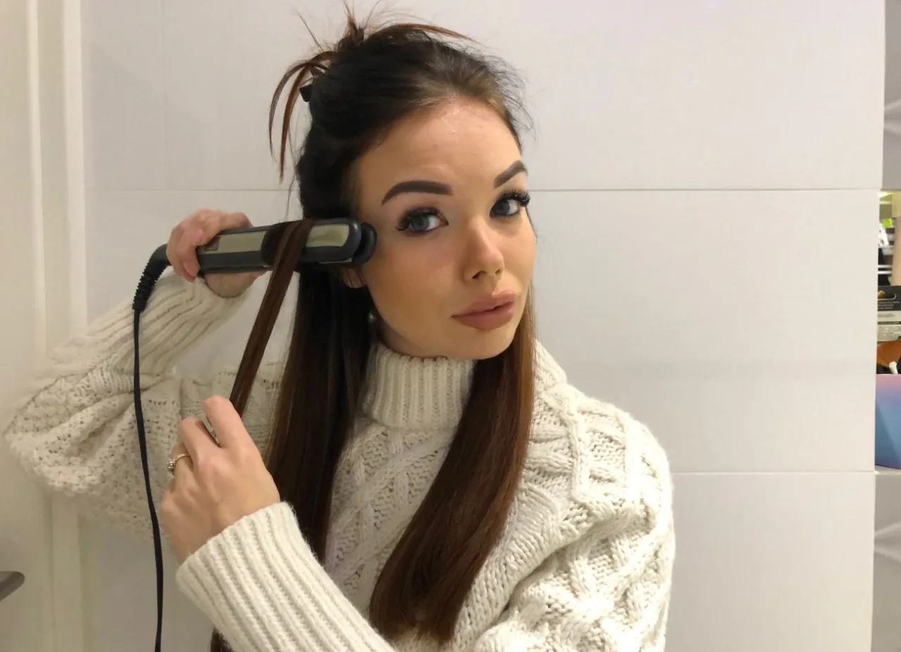 Kobieta tworzy loki prostownicą, pokazując jak zrobić loki prostownicą.