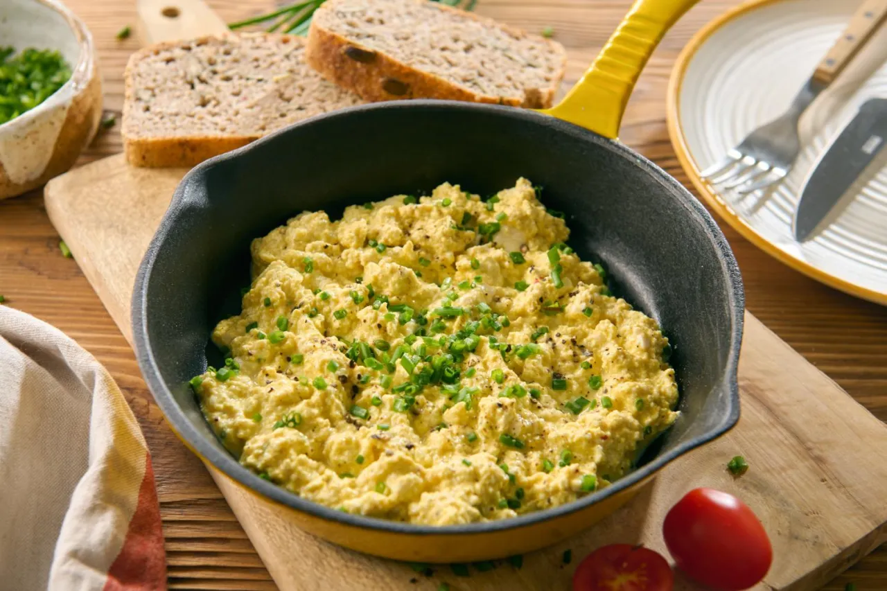 Jajecznica z tofu, idealna jako wegańska alternatywa dla jajek. Podana z pieczywem i szczypiorkiem.