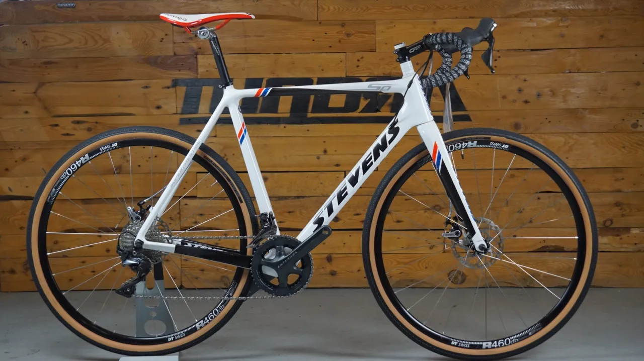 Biały rower szosowy Stevens z brązowymi oponami. Zastanawiasz się, ile kosztuje wymiana przerzutek w rowerze?