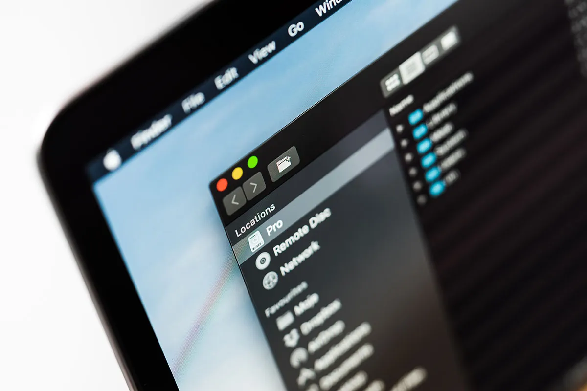 Na ekranie MacBooka widać okno Findera z listą lokalizacji, w tym 