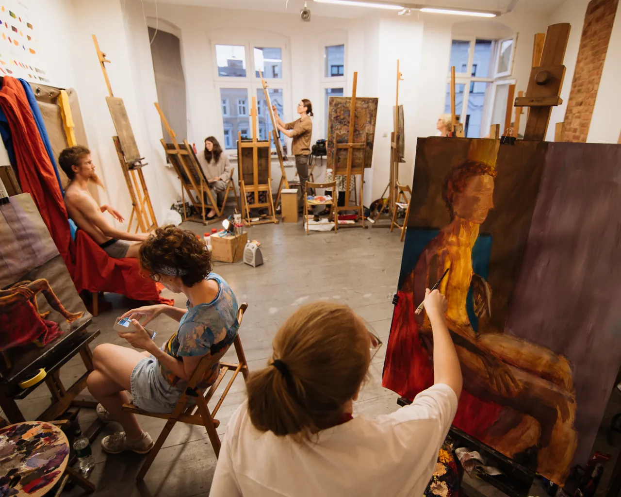 Dorośli na warsztatach artystycznych malujący obrazy