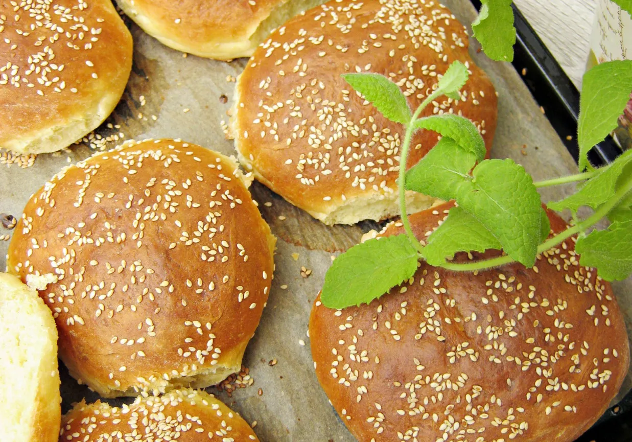 Świeżo upieczone bułki do hamburger&oacute;w, posypane sezamem, gotowe do podania. Idealne, by pokazać, jak upiec bułki do hamburger&oacute;w.