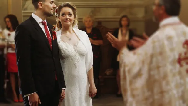 Para młoda w kościele, ksiądz wygłaszający kazanie