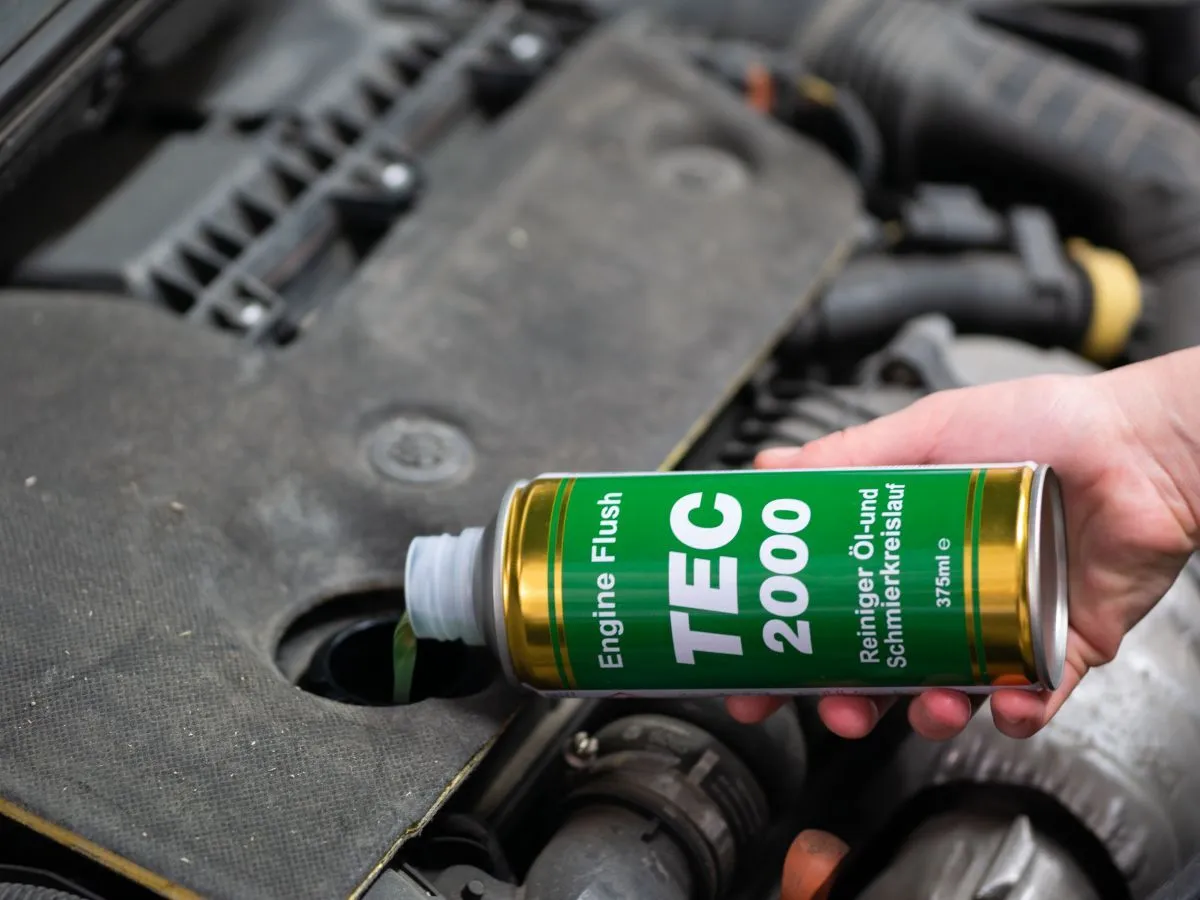 Ręka wlewa płyn do płukania silnika TEC 2000 do otworu. Czy płukanie silnika jest bezpieczne? To pytanie zadaje sobie wielu kierowców.