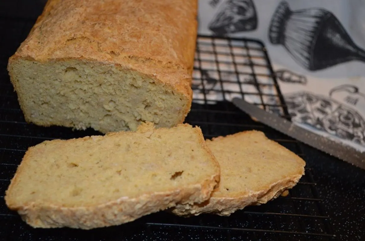 Domowy chleb owsiany bezglutenowy, pokrojony na kromki, leży na kratce. Idealny przepis dla każdego.