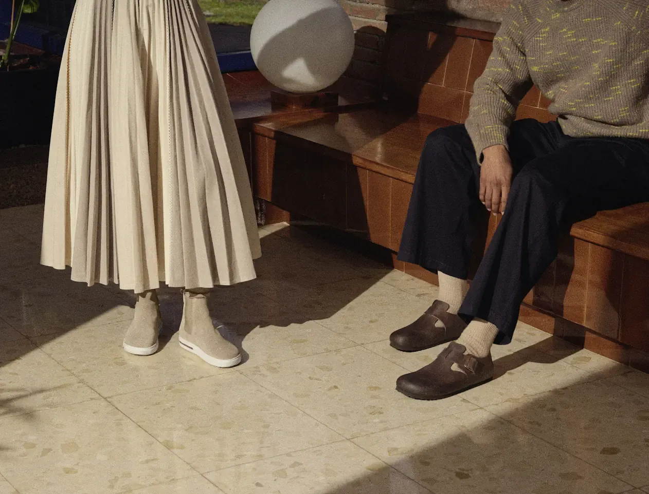 Elegancka jesienna stylizacja: plisowana sp&oacute;dnica i sweter z zamszowymi botkami lub p&oacute;łbutami.