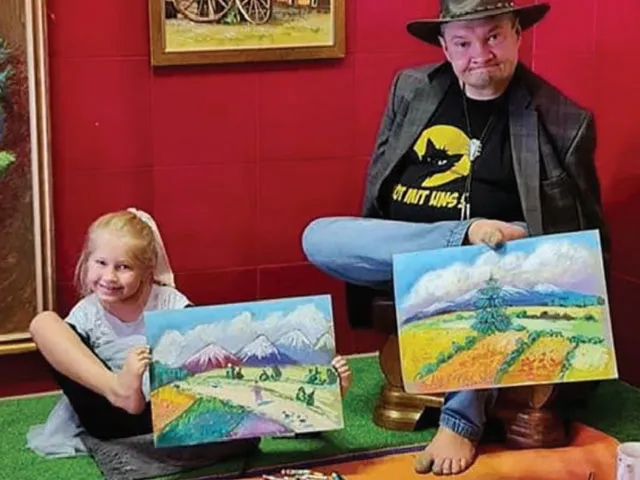 osoba niepełnosprawna malująca obraz z opiekunem