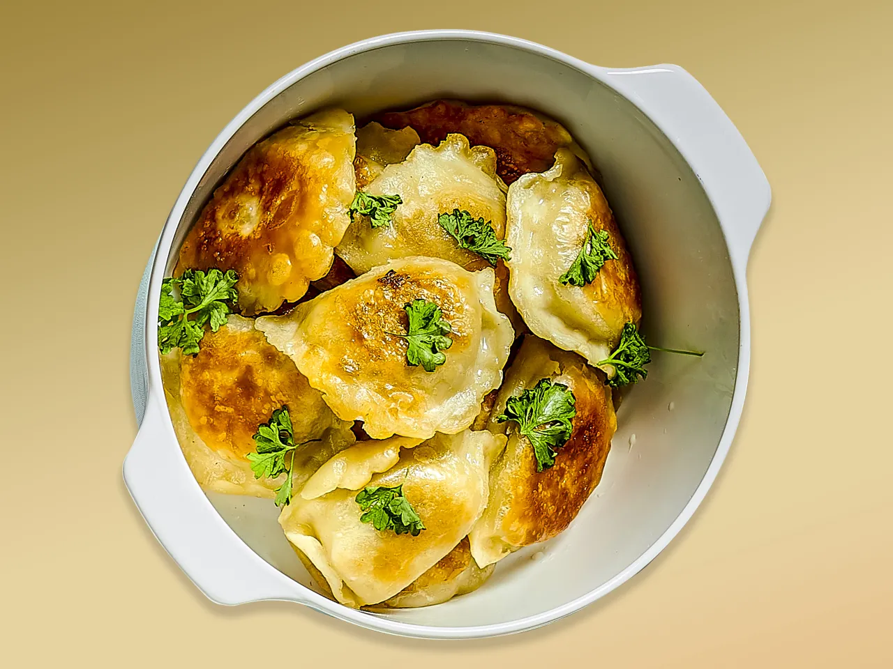 Złociste, rumiane pierogi z serem i ziemniakami, ozdobione natką pietruszki. Idealne, gdy zastanawiasz się, jak długo gotuje się pierogi.