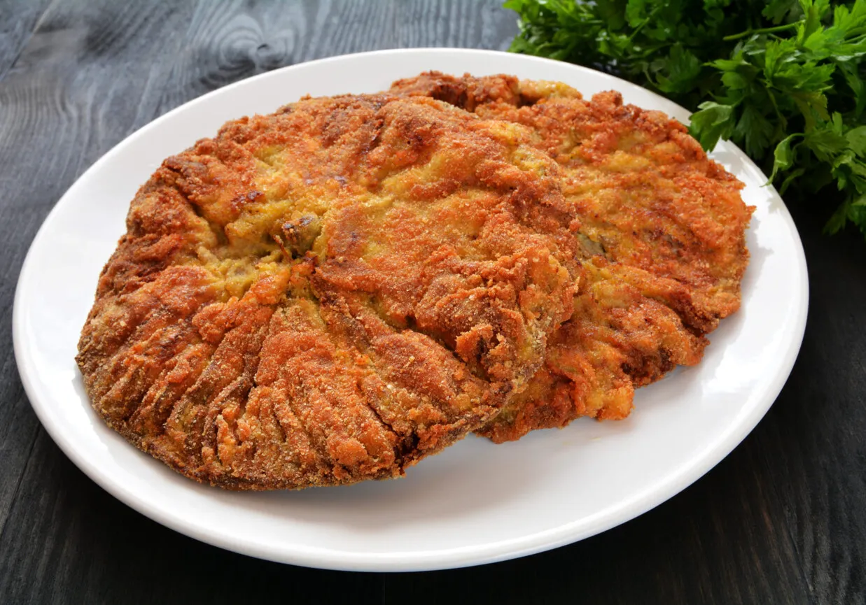 Złociste, panierowane kotlety z kani na białym talerzu. Idealne, gdy wiesz, jak smażyć mrożone kanie.