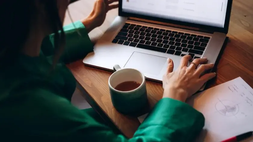 osoba pisząca recenzję na laptopie