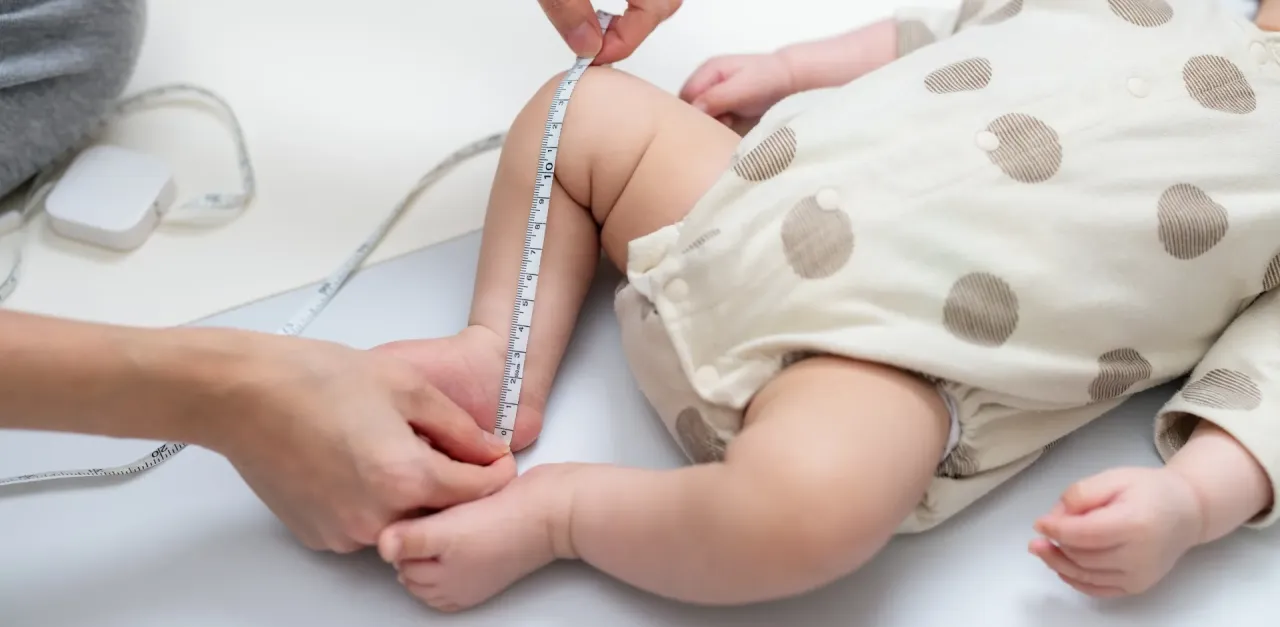 dziecko mierzone miarką krawiecką, dziecko mierzące stopę