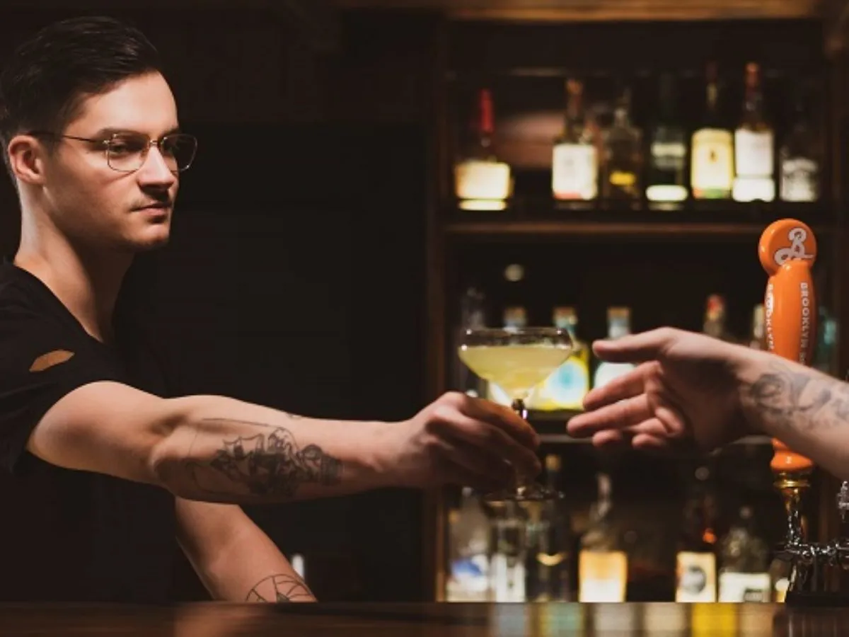 barman w eleganckim koktajlbarze przygotowuje drinka