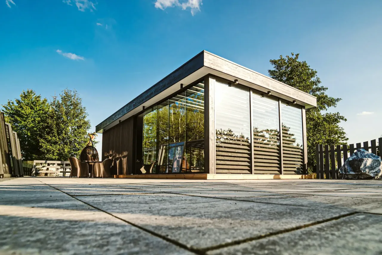 Nowoczesna altana z drewnianymi i szklanymi ścianami, idealna inspiracja z czego zrobić ściany altany.