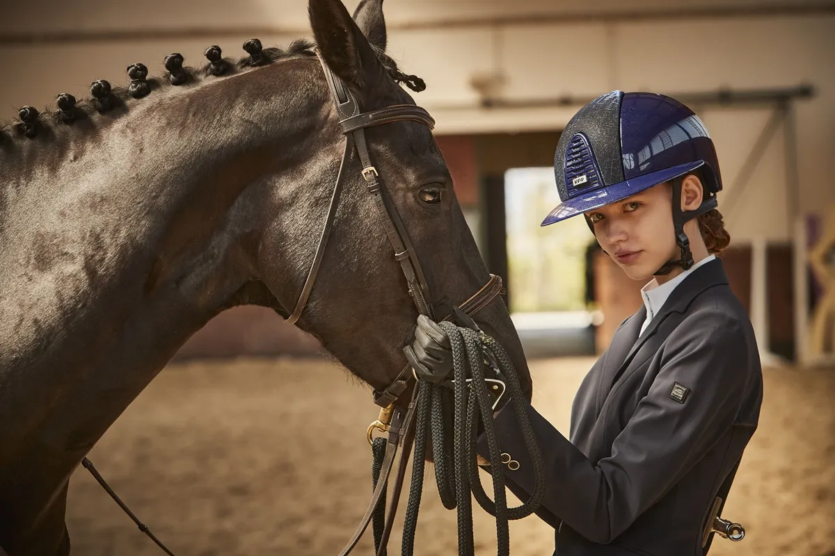 dziecko w rękawiczkach jeździeckich na koniu