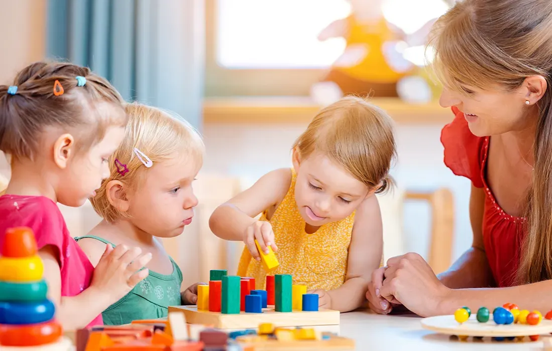 Dziecko bawi się w nowym przedszkolu, uśmiechnięte