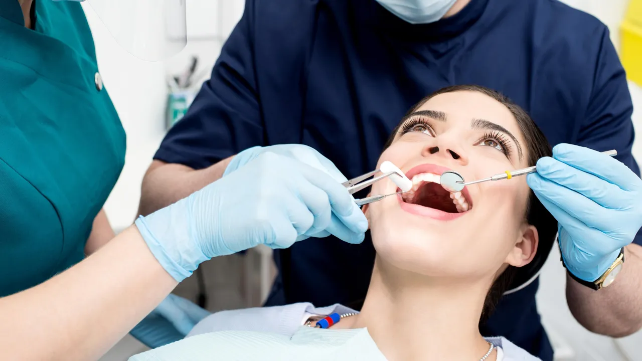 kobieta delikatnie masująca policzek po wizycie u dentysty