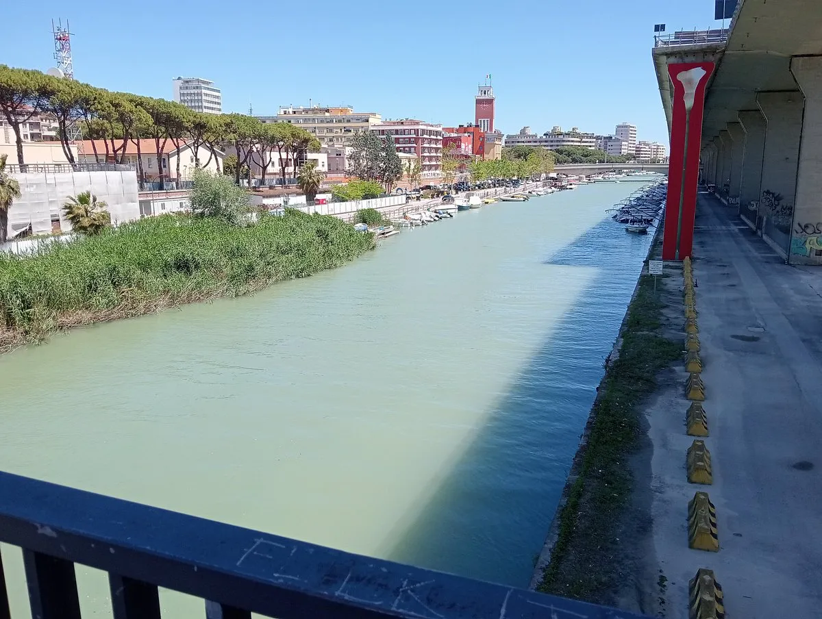 Rzeka w Pescara, z łodziami przy nabrzeżu i budynkami w tle. Warto zobaczyć w Pescara to malownicze widoki i port.