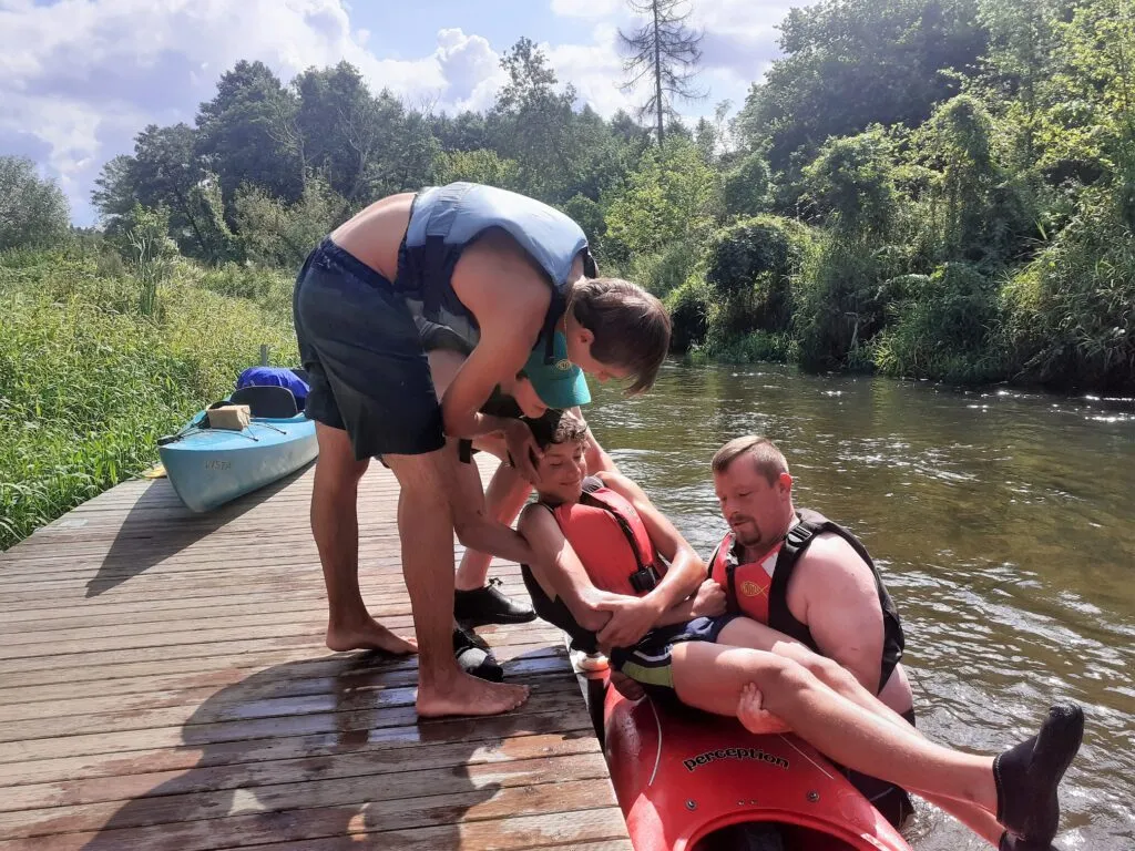 Osoby w kamizelkach asekuracyjnych na kajakach