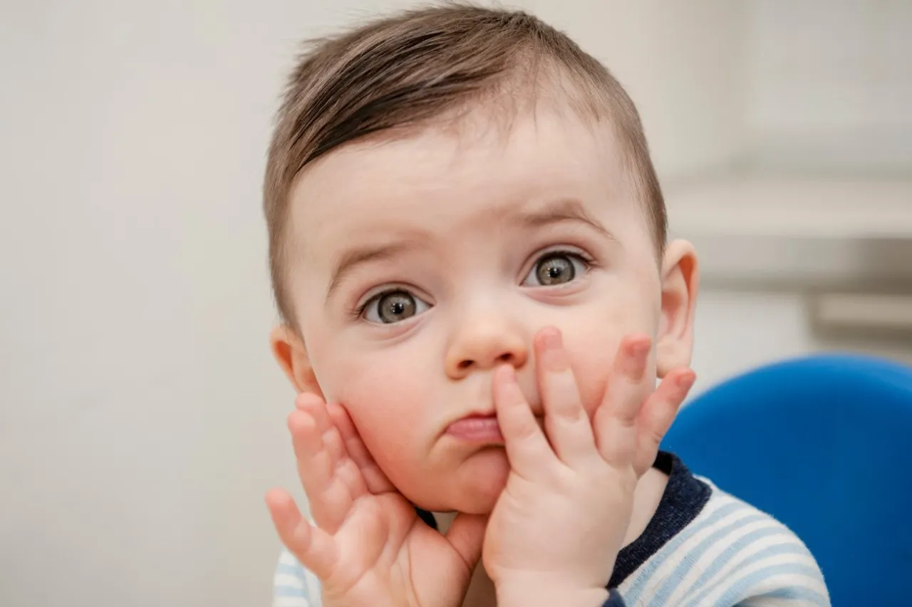 niemowlę bawi się rączkami