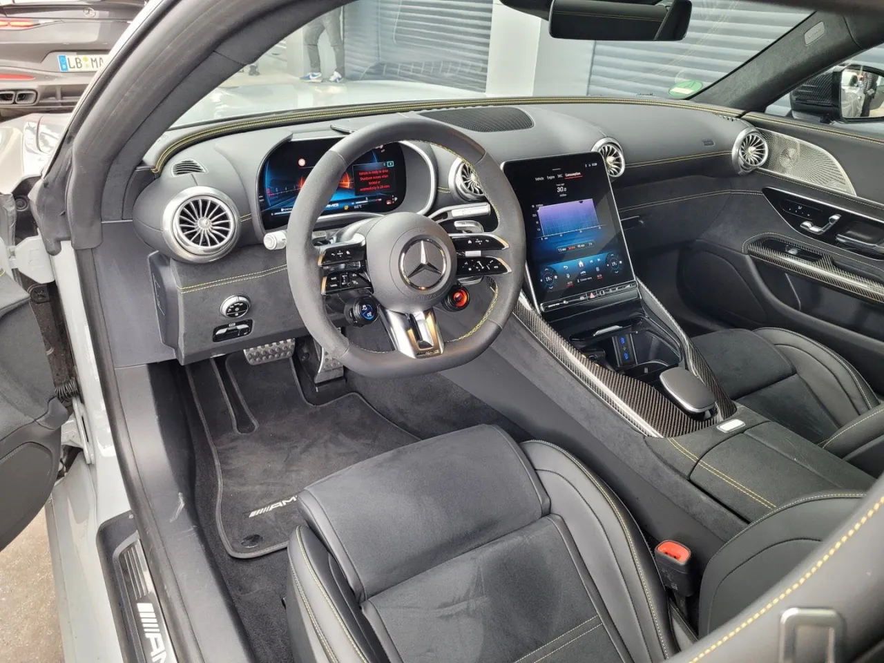 Wnętrze Mercedes-AMG GT 63 S: sportowe fotele, cyfrowe zegary i duży ekran multimedialny.