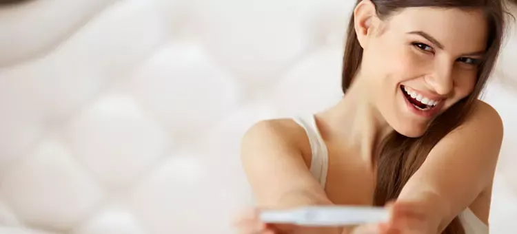 test ciążowy pozytywny, kobieta uśmiechnięta