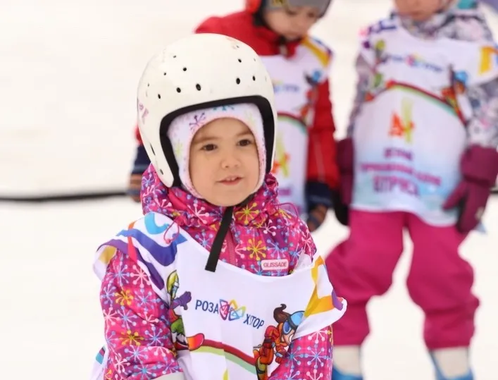dziecko w kasku i ochraniaczach na stoku
