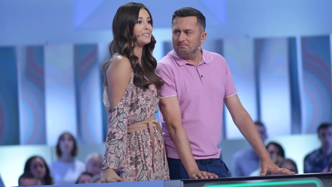 Iza Krzan w Kole Fortuny, w r&oacute;żowej sukience, obok mężczyzny w koszulce polo.