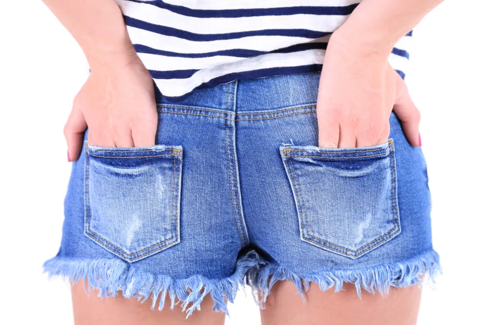 postrzępione nogawki jeansowych szortów, podwinięte mankiety szortów