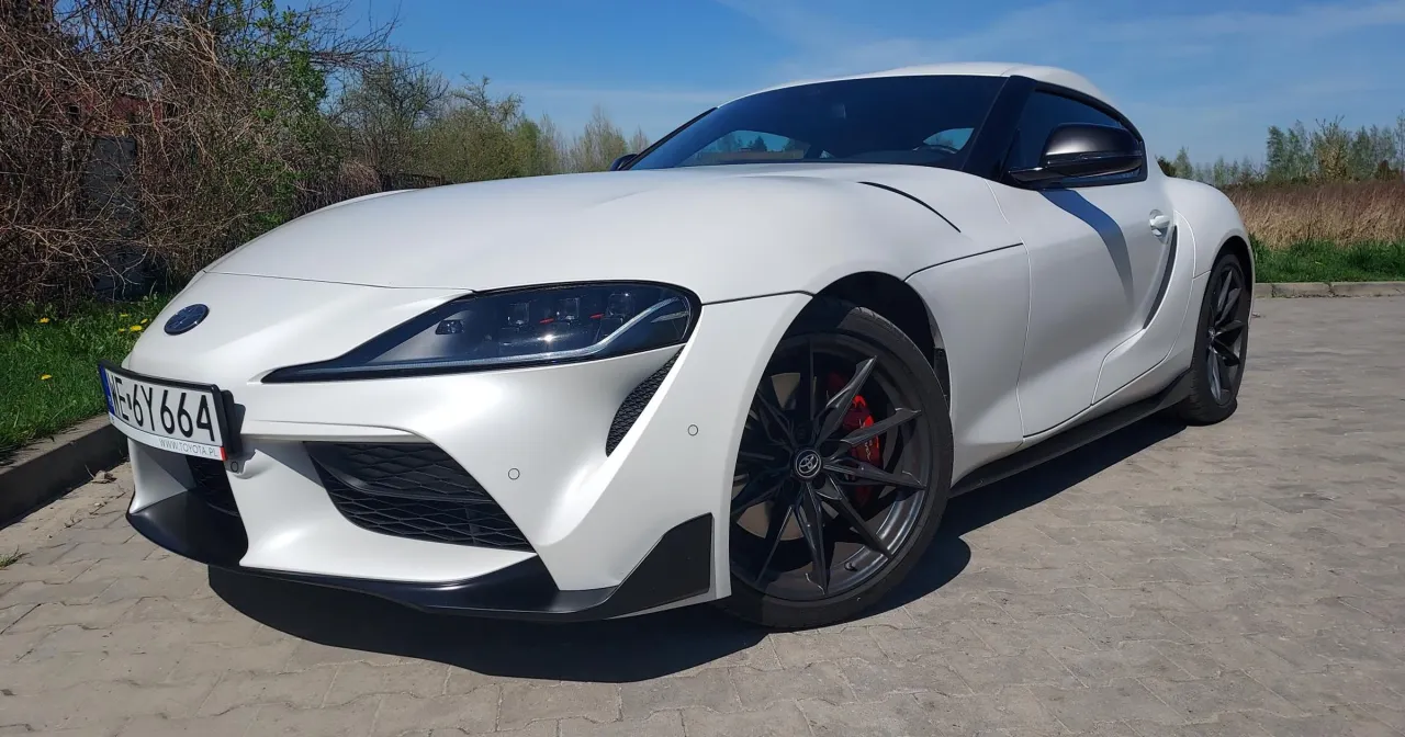 Biała Toyota Supra z czarnymi felgami i czerwonymi zaciskami hamulcowymi. Zastanawiasz się, ile kosztuje Toyota Supra?