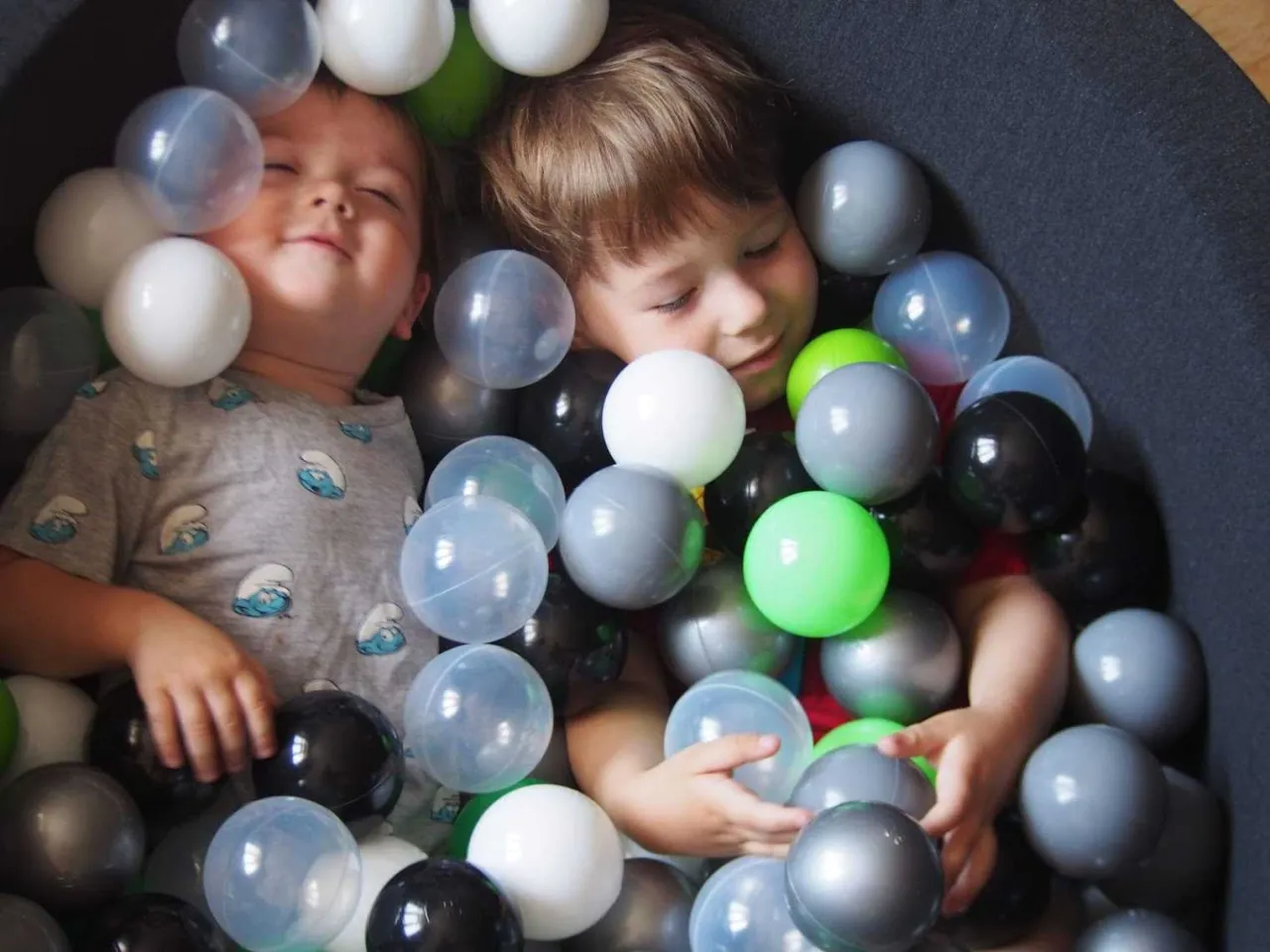 Dziecko bawi się piłkami sensorycznymi Akuku w wodzie