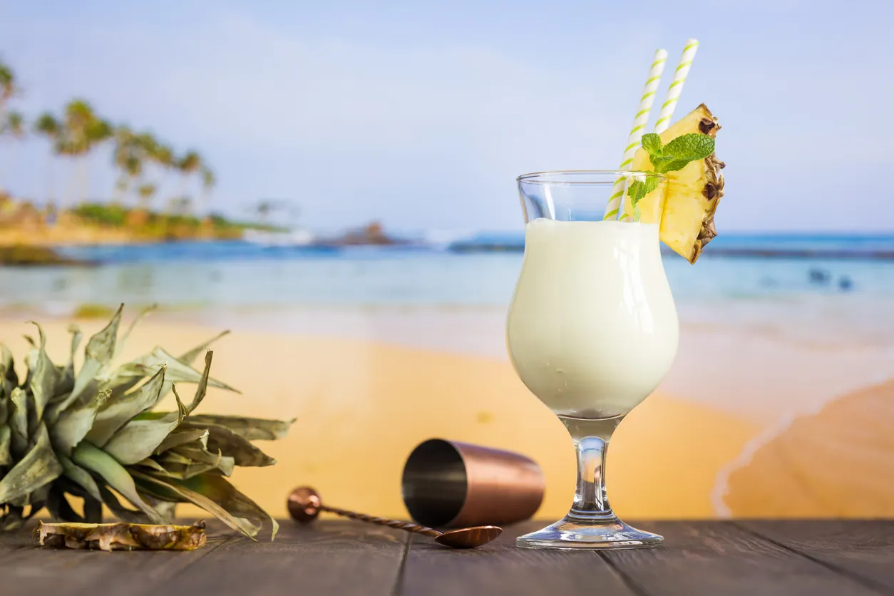 Pina Colada przepis na tropikalne orzeźwienie. Kremowy koktajl z ananasem i miętą na plaży.