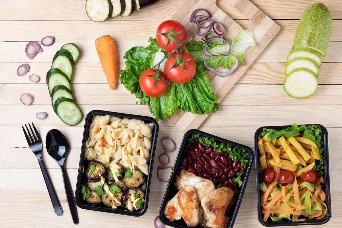 Trzy pojemniki z cateringiem dietetycznym: makaron z bakłażanem, kurczak z fasolą i frytki z sur&oacute;wką. Idealne, by dowiedzieć się, jak podgrzewać catering dietetyczny.