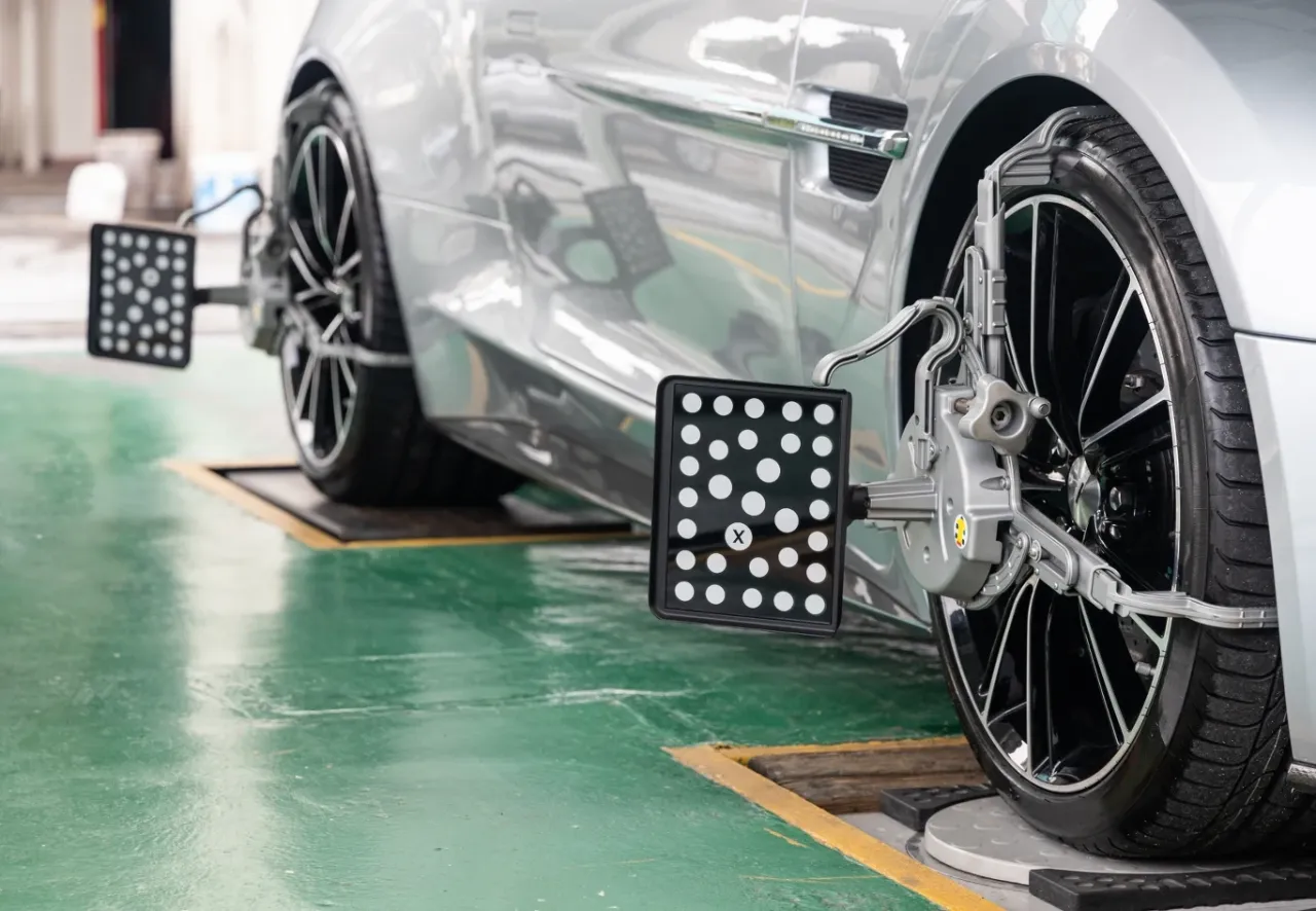 Precyzyjne ustawienie zbieżności k&oacute;ł w srebrnym aucie za pomocą specjalistycznego sprzętu. Dowiedz się, jak samemu ustawić zbieżność.