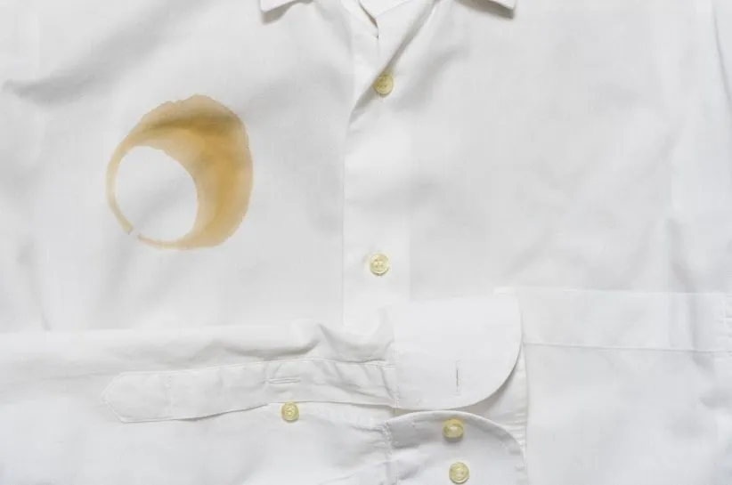 Zaschnięta plama z kawy na białej koszuli