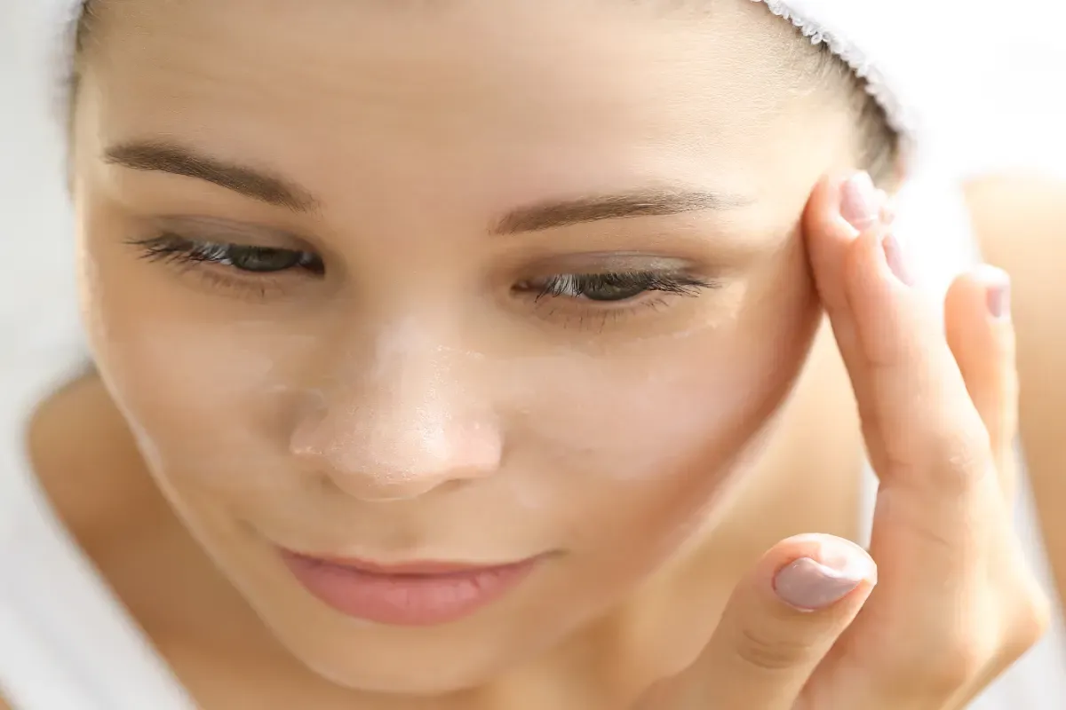 kobieta diagnozująca typ cery przed lustrem