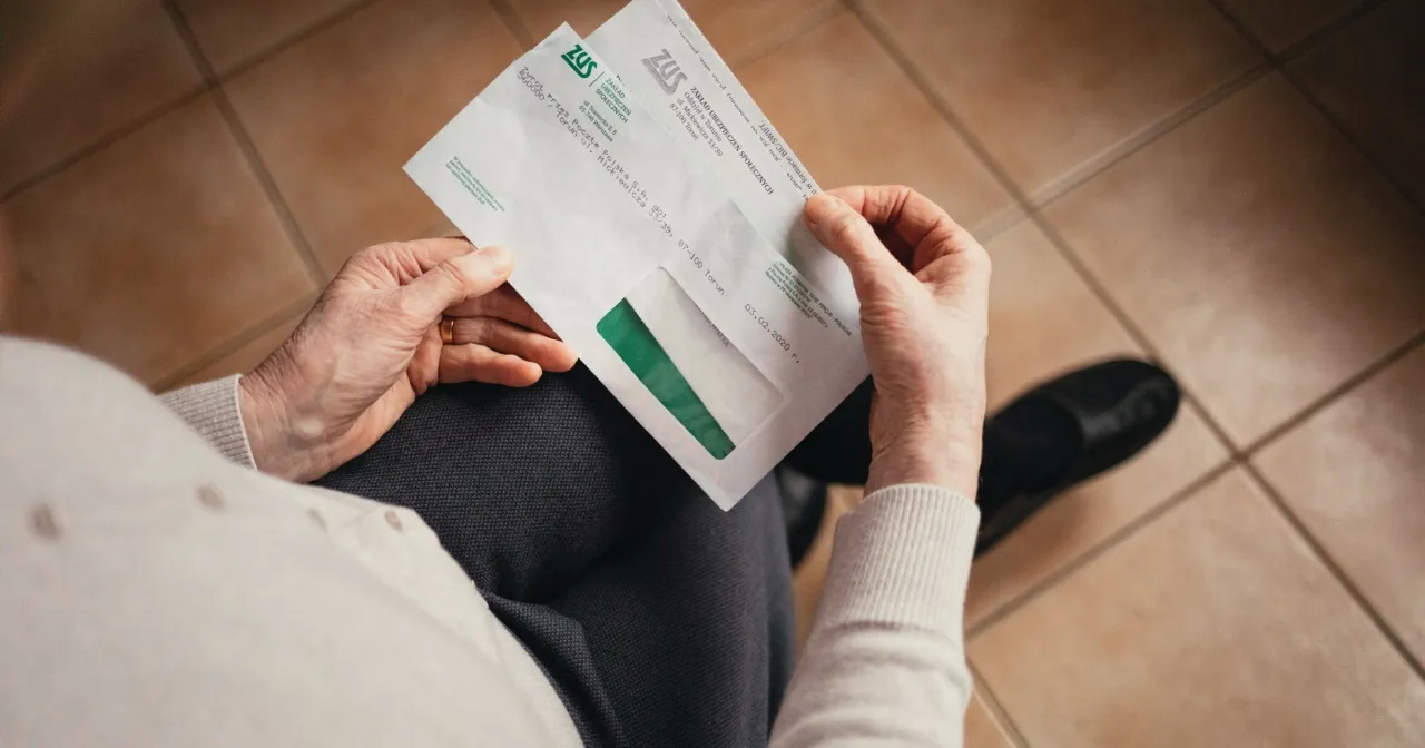 kobieta z dokumentami ZUS i kalkulatorem