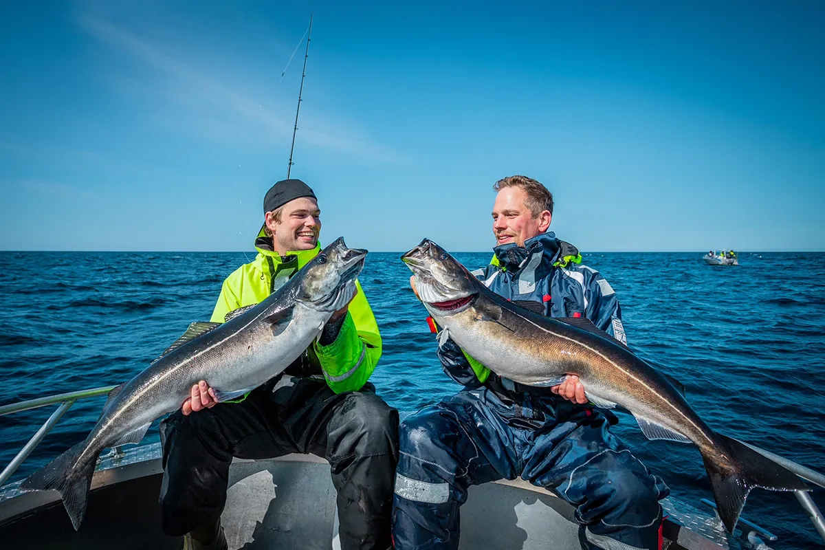 Dwóch wędkarzy z połowami na łodzi w Norwegii. Warto zabrać ciepłą odzież i sprzęt wędkarski.