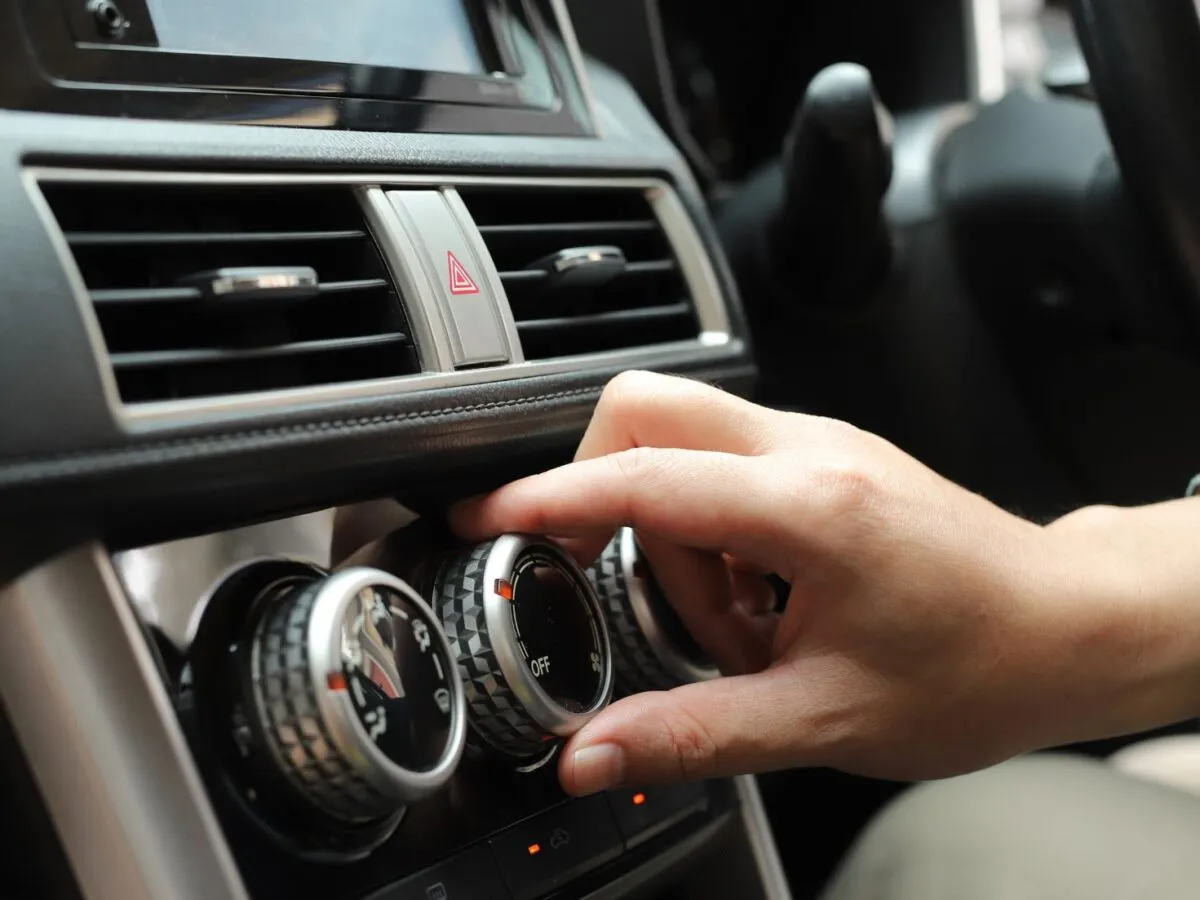 Dłoń kręci pokrętłem klimatyzacji na