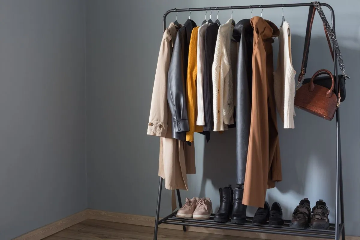 kobieta uśmiechnięta przed uporządkowaną szafą, minimalistyczna szafa