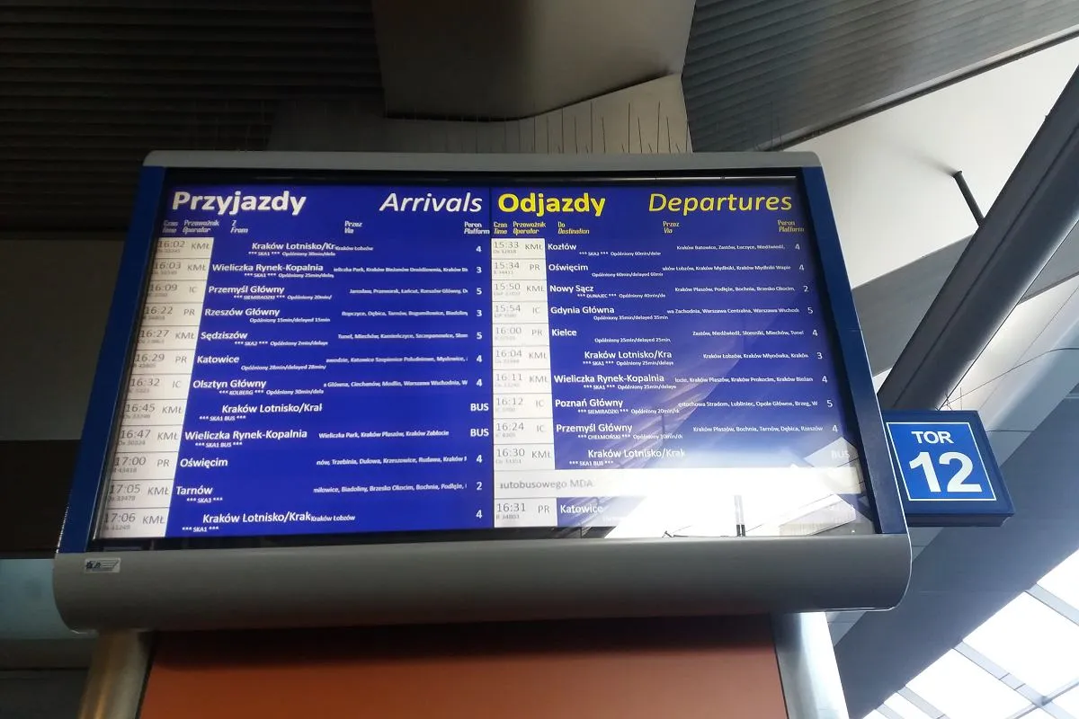 Tablica odjazd&oacute;w pokazuje, że pociąg do Katowic odjeżdża z toru 12.