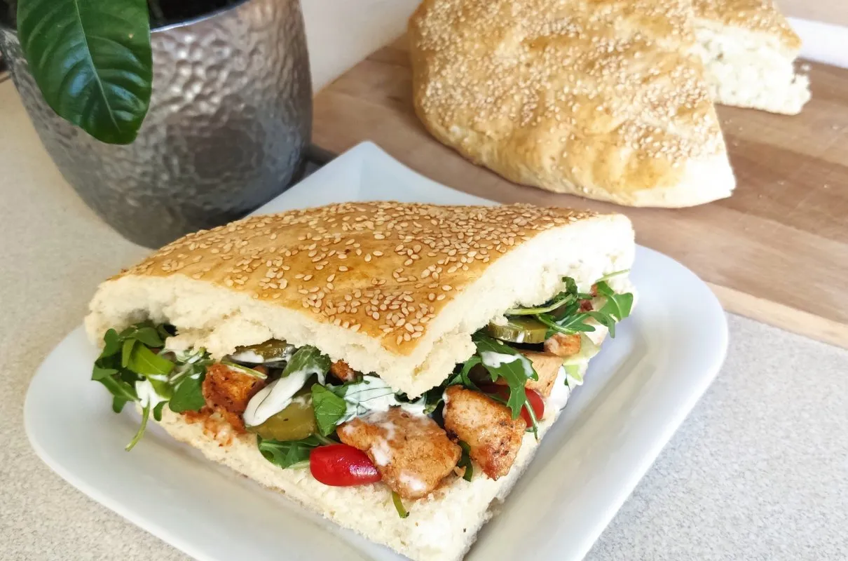 Pyszny kebab w bułce z sezamem, pełen mięsa, warzyw i sosu. Czy kebab to fast food? Ten wygląda na tak pyszny, że warto go spróbować!